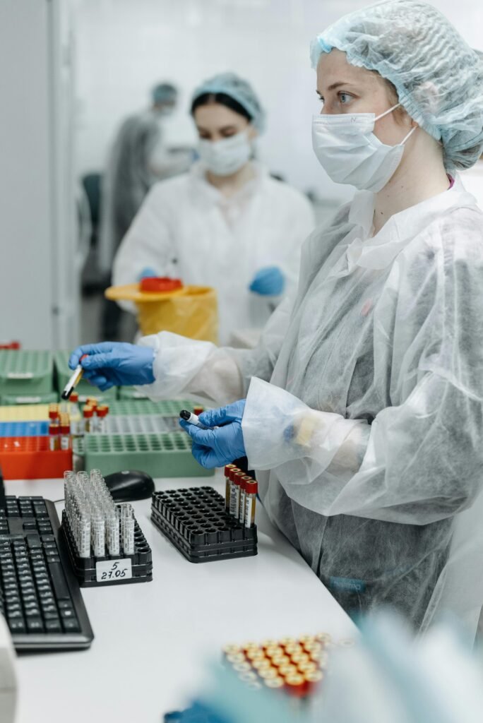 Lab technicians in protective gear analyzing samples, highlighting pandemic research efforts.