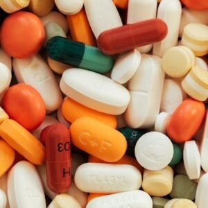 Close-up of assorted colorful pills and tablets on a surface.